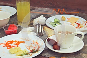 Messy table after party. Leftover food, spilled drinks, dirty dishes.