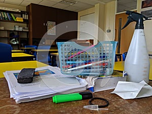 A messy teachers desk in a classroom