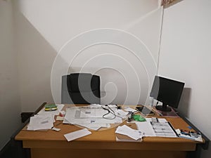 Messy/ untidy small office with papers all over the desk 2