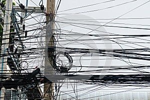 Messy wires attached to the electric mast. chaos of cables and wires on an electric pole. Many electrical cable - wire and