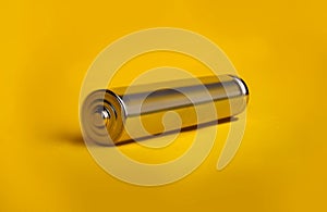 metal AAA battery on a yellow background close-up