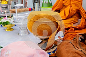 A metal alms bowl covered with golden-orange cloth to receive food from laypeople and people who believe in Buddhism