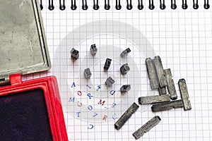 Metal alphabet stamp punch and red, blue ink.