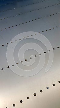 Metal. Aluminum. Sheet metal with rivets. Metal plate with rivets. Metallic surface. Industrial background