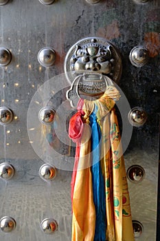 Metal anicient door with animal head door knocker in Tibetan Buddhist temple, Laji Shan Qinghai Province China photo