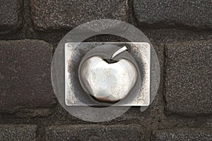 A metal apple on the cobblestone in the old town