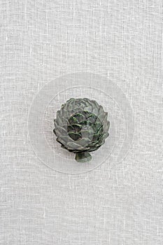 Metal artichoke on canvas background