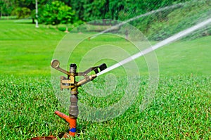 A metal automatic water sprinkler in the field