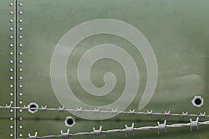Metal background with holes from bullets and barbed wire
