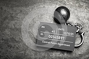 Metal ball with chain and mugshot letter board on grey table, flat lay. Space for text