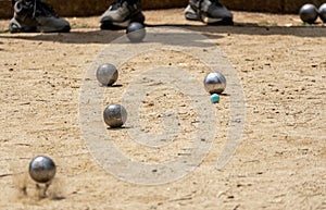 Metal ball from the game of petanque approaching the green bowling alley bouncing off the sandy ground kicking up dust and grit