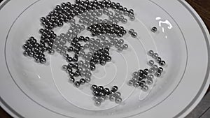 Metal balls moving in a plastic plate by moving a magnet underneath.