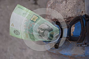 Metal barrel and Ukrainian money, the concept of the cost of gasoline, diesel, gas. Refilling the car. Banknote 20 Ukrainian