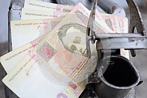 Metal barrel and Ukrainian money, the concept of the cost of gasoline, diesel, gas. Refilling the car.