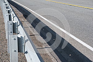 Metal barriers on side of asphalt road. Ensuring traffic safety on highway