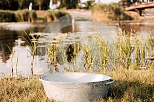 Metal basin near the lake on a sunny summer day