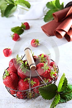 Metal basket with fresh strawberries. Strawberry pastille is rolled into a tube. Natural product. Copy of the space. Vertical