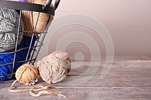 Metal basket with knitting yarn on table