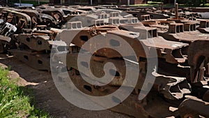 Metal beams of superstructure bogie of freight cars of train in open-air warehouse on sunny summer day. Heap of large