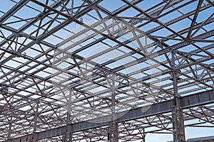 Metal beams of top of unfinished steel construction of the building under construction