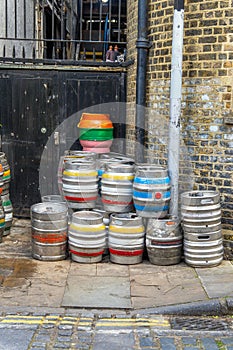 Metal beer kegs stacked on the sidewalk on Rotherhithe Street at the Mayflower Pub in London