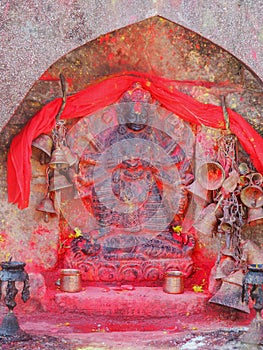 Metal bells offered by devotees at Kali Temple. Shrine full of red pigment to worship Goddess Kali at Dhulikhel in Nepal