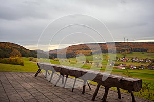 a metal bench with a speaker on it's back end and a grassy area in the background with trees