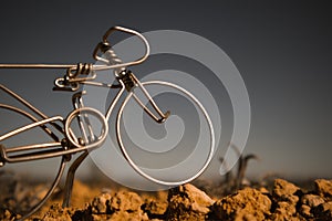 A metal bicycle against a grey sky. Toy souvenir craft mini bike Mountain biking