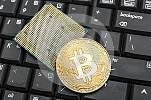 Metal bitcoin with computer processor on keyboard. Close up. Business concept