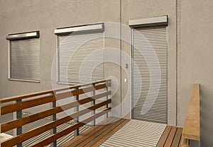 Metal blinds on the doors and windows of the facade of the house