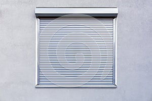 Metal blinds on the window of the facade of the house