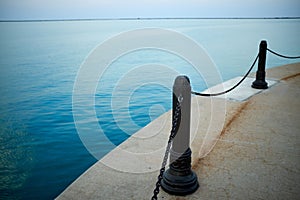 Metal bollards with safety chains on a pier