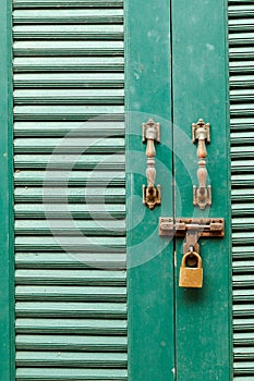 Metal bolts, latches and hooks in green wooden door