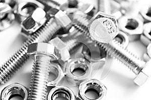 Metal bolts and nuts in a row background. Chromed screw bolts and nuts isolated. Steel bolts and nuts pattern. Set of Nuts and bo