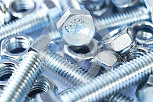Metal bolts and nuts in a row background. Chromed screw bolts and nuts . Steel bolts and nuts pattern. Set of Nuts and bo