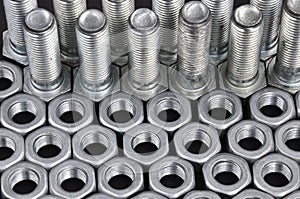 Metal bolts and nuts in a row background. Steel bolts and nuts pattern. Set of Nuts and bolts