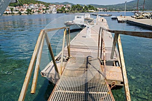 A metal bridge leading to the dock with boats