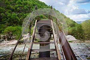 Metal bridge over mountain river