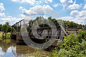 Metal Bridge Over River Under Blue Cloudy Skies