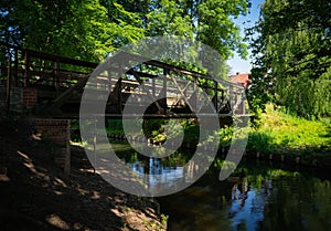 Metal bridge over a swamp surrounded by lush greenery in Burg Spreewald, Germany