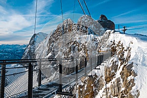 Suspended bridge over a snowy valley in Alps photo