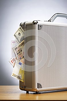 Metal briefcase full of cash on table