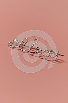 Metal brooch with the inscription name Alex on a pink background vertical