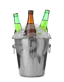 Metal bucket with bottles of beer and ice cubes isolated on white