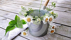 Metal bucket with a bouquet of daisies and a white towel. Bath accessories and wildflowers