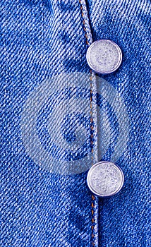 Metal buttons on blue jeans.