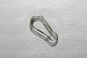 Metal carabiner on gray background