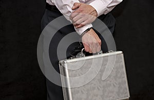 Metal case handcuffed to a man, close-up, selective focus. Transfer of documents Concepts: sale of secrets, espionage, arrest of a