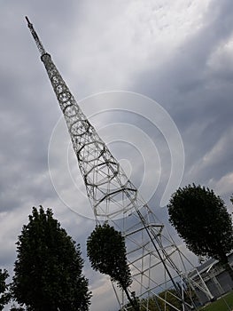 Metal cell phone tower against an overcast sky