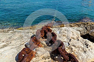 A metal chain attached to the bollard at port